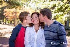 a woman and two boys kissing each other