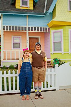 a man and woman standing in front of a house that has been painted multicolored