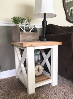 a small table with a clock on it next to a couch