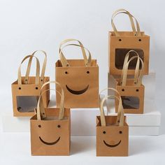 six brown bags with smiley faces on them are sitting on top of each other in front of a white background