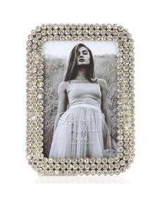 a woman wearing a white dress is shown in a silver frame with pearls on it