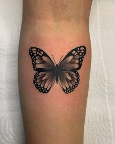 a black and white butterfly tattoo on the leg