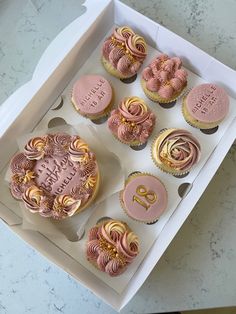 a box filled with pink and gold cupcakes