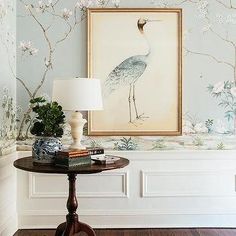 a table with a lamp and painting on the wall