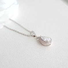 Pretty Emma crystal bridal necklace created with a shiny teardrop pendant. Small Cubic Zirconia tear drop set in an open setting surrounded by tiny cubic zirconia crystals, it is 16 mm in size. I have put it onto a cubic zirconia detailed bail and a rhodium plated brass chain. It is also available in rose gold finish and 14k gold finish. Ideal as a bridesmaid necklace or also as a flower girl gift as it is small. The pendant is put onto a chain available in two lengths, 16 inches and 18 inches. Simple Bridal Necklace, Sparkly Necklace, Beautiful Gold Necklaces, Sparkle Necklace, Cubic Zirconia Necklace, Matching Jewelry, Pretty Necklaces, Teardrop Pendant, Bridesmaid Necklace