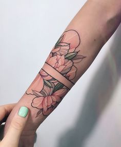 a woman's arm with flowers and a ribbon on it