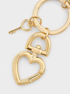 two gold heart shaped key chains on a white background