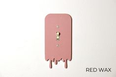 a pink light switch cover with dripping paint on it and the words red wax written below