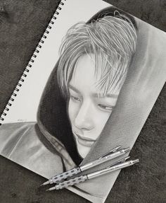 a pencil drawing of a young person with long hair and wearing a hood, holding two pens