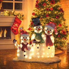 a group of snowmen standing in front of a christmas tree