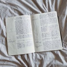 an open book sitting on top of a bed