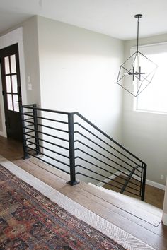 a living room with a rug and stairs