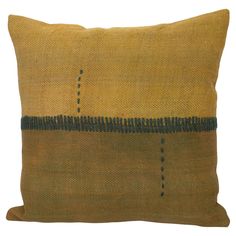 a brown and black pillow with stitching on the front, sitting on a white background