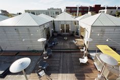 an aerial view of a roof deck with chairs and umbrellas on the top floor