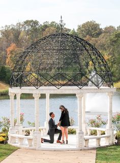 a man and woman standing in front of a gazebo