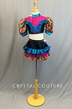 Multi colored patterned lycra includes Orange, Turquoise Blue and Fuchsia. Multi colored fabric creates puffy sleeves and bottom ruffle of skirt with Blue shiny lycra ruffle accents on top as well as ruffle on the skirt. Pink glitter lace ruffle on the skirt as well as neckline and chest of crop top. Black shiny lycra pulls it all together with crystal 20ss rhinestones to trim top and belt of skirt. *Accessories include Black sheer fingerless gloves with Blue bows at wrists, and 2 Multi colored Fitted Ruffled Skirt For Costume Party, Fitted Multicolor Skirt With Attached Cancan, Blue Fitted Skirt With Ruffles, Fitted Blue Skirt With Ruffles, Fitted Purple Skirt With Ruffles, Fitted Blue Skirt With Attached Cancan, Sheer Fingerless Gloves, Skirt Accessories, Orange Turquoise