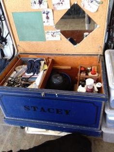 an open suitcase sitting on top of a table next to a trash can and other items