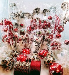 a table topped with lots of red and white christmas ornaments next to candy canes