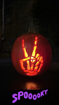 a pumpkin carved to look like a hand with beer bottles in it and the words spooky written on it