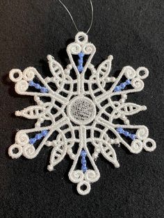 a white snowflake ornament with blue beads