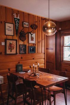 a dining room with wood paneling and pictures on the wall