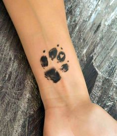 a person with a tattoo on their wrist and paw prints in the middle of it