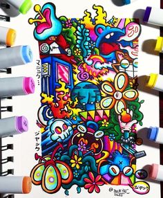 some markers and pens are on top of a paper with an image of colorful objects