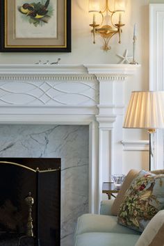 a living room with a fire place next to a painting on the fireplace mantel