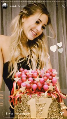 a woman holding a cake with red berries on it