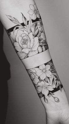 a black and white photo of a flower on the arm, with flowers in it