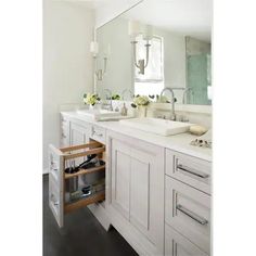 a white bathroom with two sinks and drawers