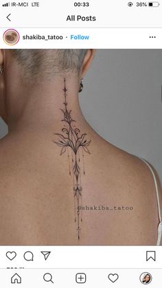 the back of a woman's neck is shown with tattoos on her upper and lower