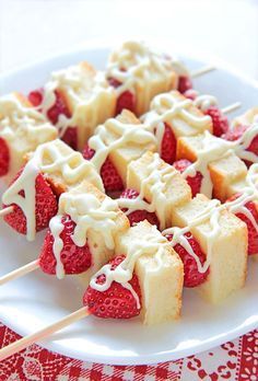 strawberry shortbreads with white icing and drizzled on them sitting on a plate