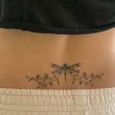 a woman with a dragonfly tattoo on her stomach