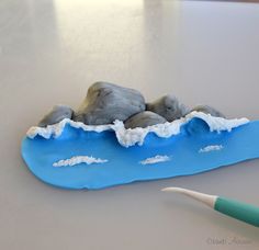 a toothbrush sitting on top of a blue plate with rocks and water in it