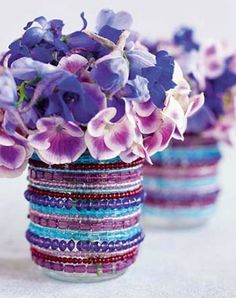 two vases filled with purple flowers on top of a table