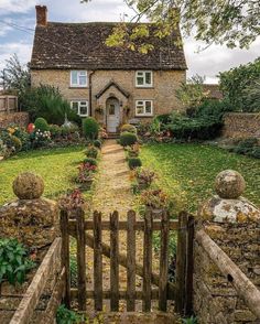 a stone house with a wooden fence in the front yard