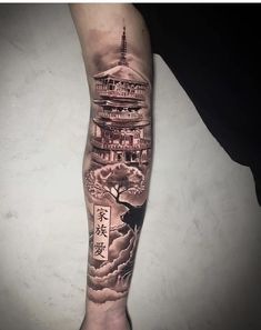 a person with a tattoo on their arm that has an image of a pagoda and clouds