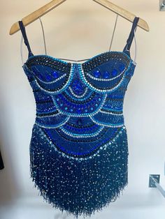 a blue dress hanging on a wooden hanger