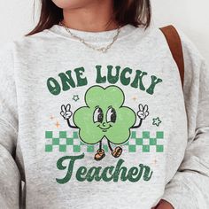 How cute is this retro St. Patricks Day sweatshirt? This crewneck is sure to be loved by teachers and students for years to come. This is the perfect St. Patrick's Day gift for that one lucky teacher in your life! ----------------------------------------------------------------------------------------------------------------------- Handmade with production assistance SIZING Unisex - depends on each shirt type (see size chart for more details). It is recommended to reduce your size for a more fem Cute Letter Print Sweatshirt For School, Retro Cotton Sweatshirt With Funny Print, Cute Green Sweatshirt With Letter Print, Green Cotton Sweatshirt For School, Green Crew Neck Sweatshirt For School, Retro St Patricks Day, St Patrick's Day Outfit, Teaching Outfits, St Patricks Day Shirt