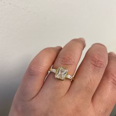 a woman's hand with a yellow and white diamond ring on top of it