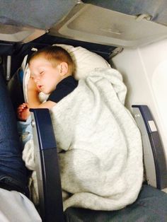 a young boy sleeping in an airplane seat