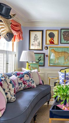 a living room filled with furniture and pictures on the wall above it's windows