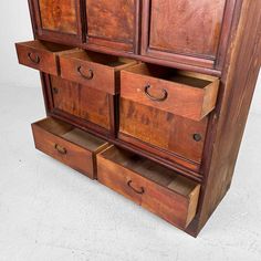 an old wooden cabinet with drawers on top