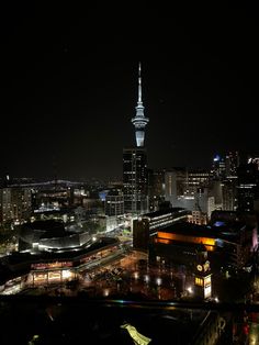 the city skyline is lit up at night, with lights on and buildings in the foreground