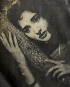 an old black and white photo of a woman with her arm wrapped around a pillow