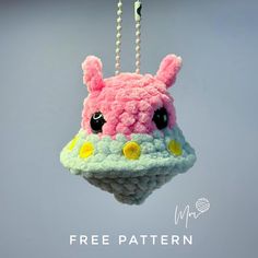 a crocheted stuffed animal hanging from a hook with beads on it's end