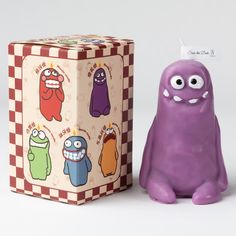 a purple toy next to a box with monsters on it