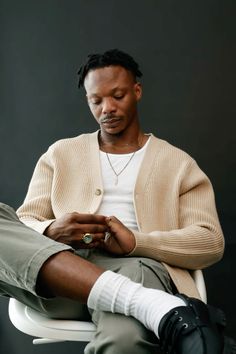 a man sitting on top of a chair looking at his cell phone in his hand