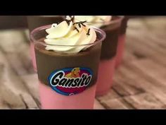 two cups filled with ice cream on top of a wooden table